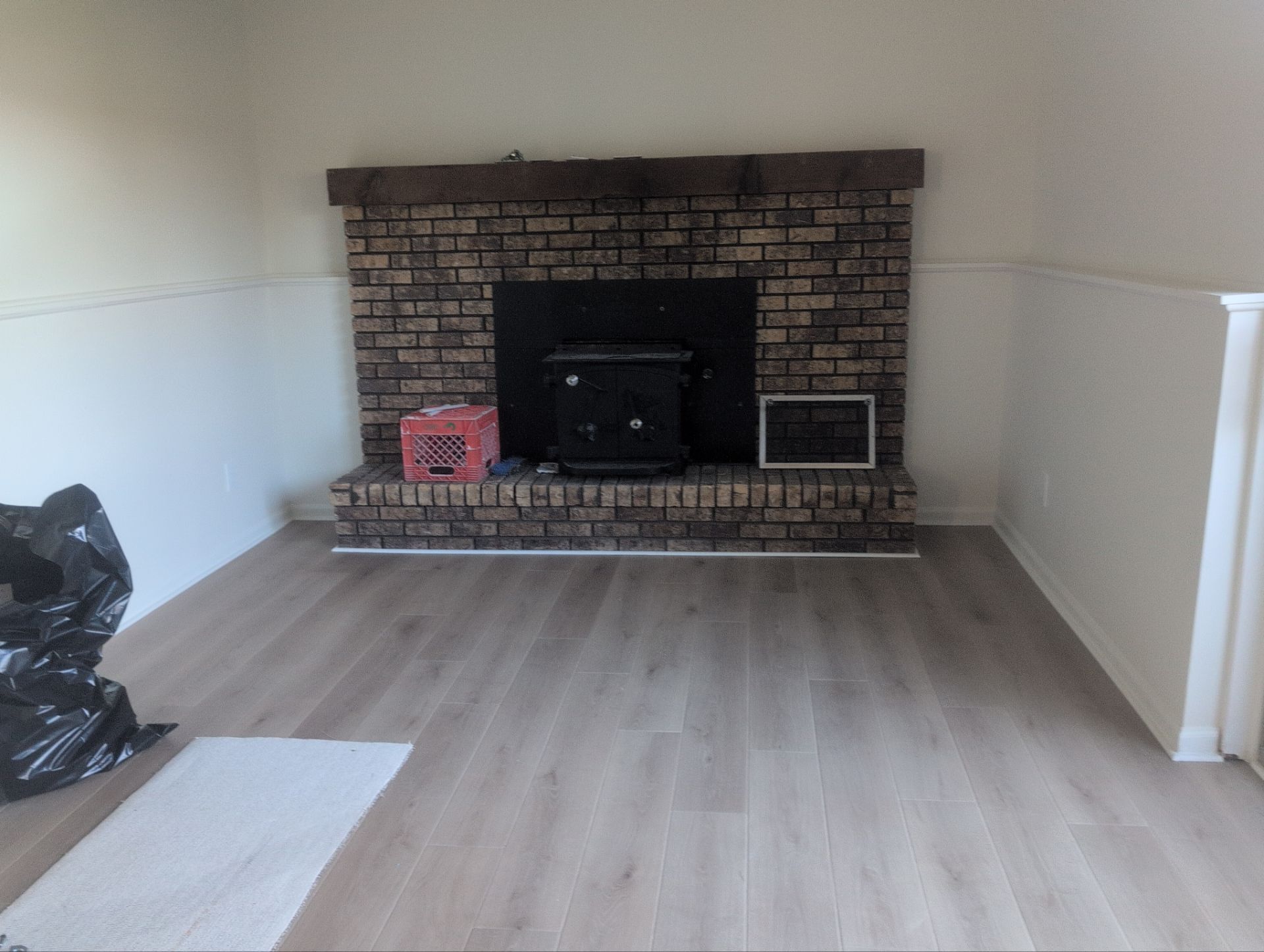 Updated residential living room with brick fireplace and new flooring